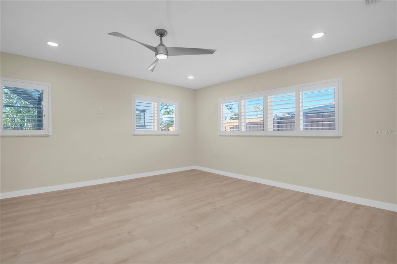 The primary bedroom is generously sized and enhanced with timeless plantation shutters.