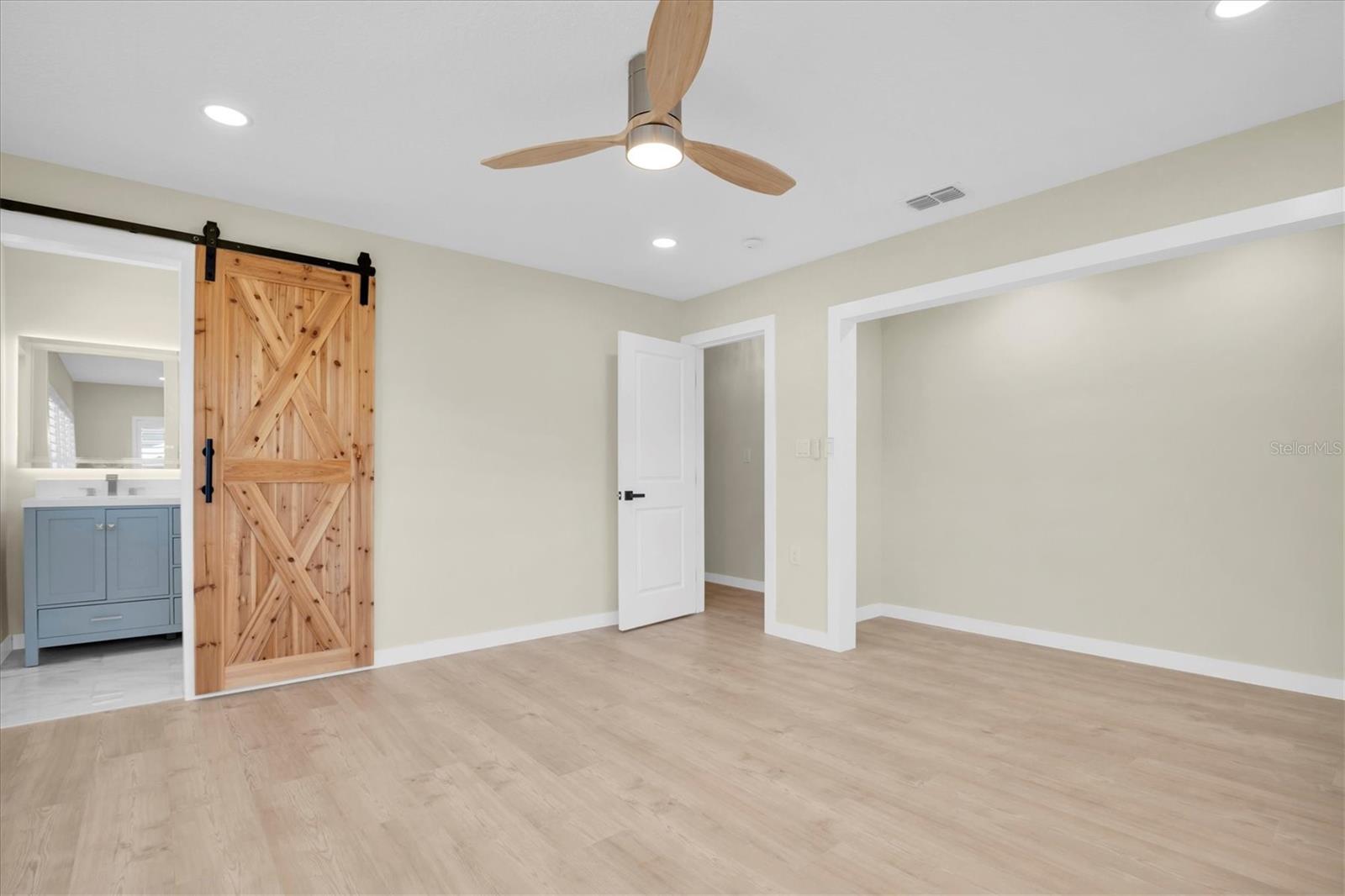 The third bedroom is enhanced by a sophisticated barn style door, offering seamless access to the shared Jack-and-Jill bathroom.