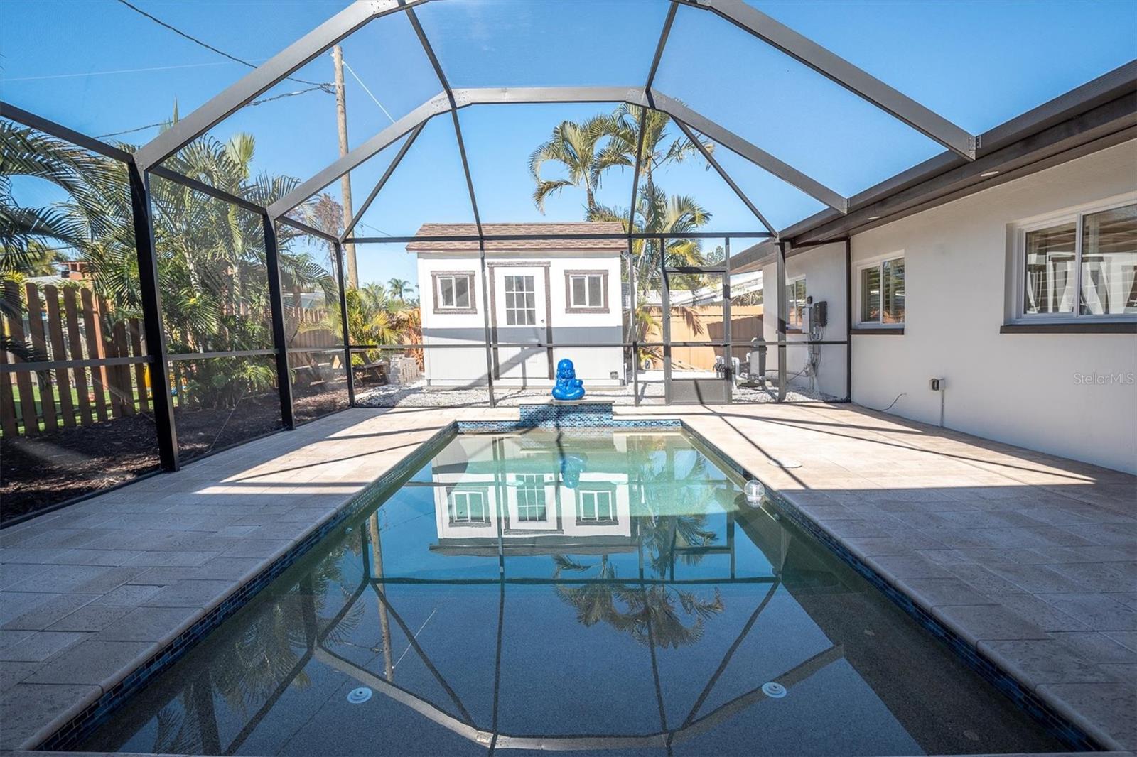 Outdoors, a shimmering inground pool awaits beneath a screened enclosure, while the privately fenced yard enhances the sense of seclusion & luxury.