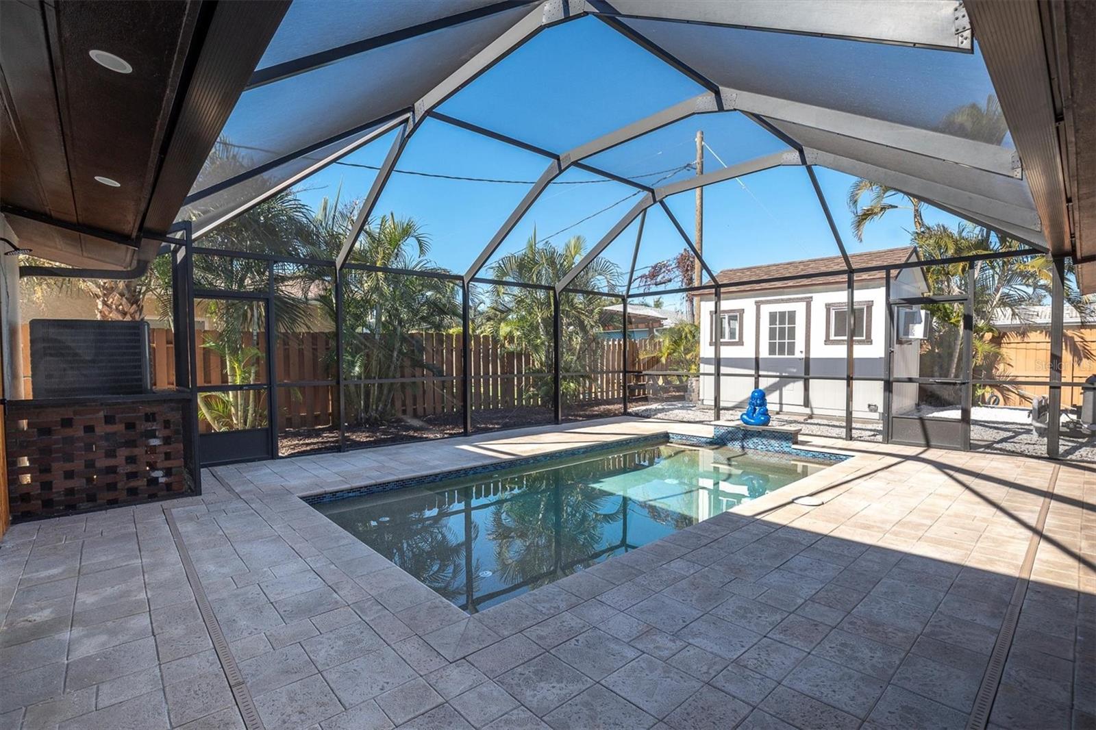 The pool is framed by stunning pavers that elevate the entire outdoor area with a rich, resort-style sense of luxury.