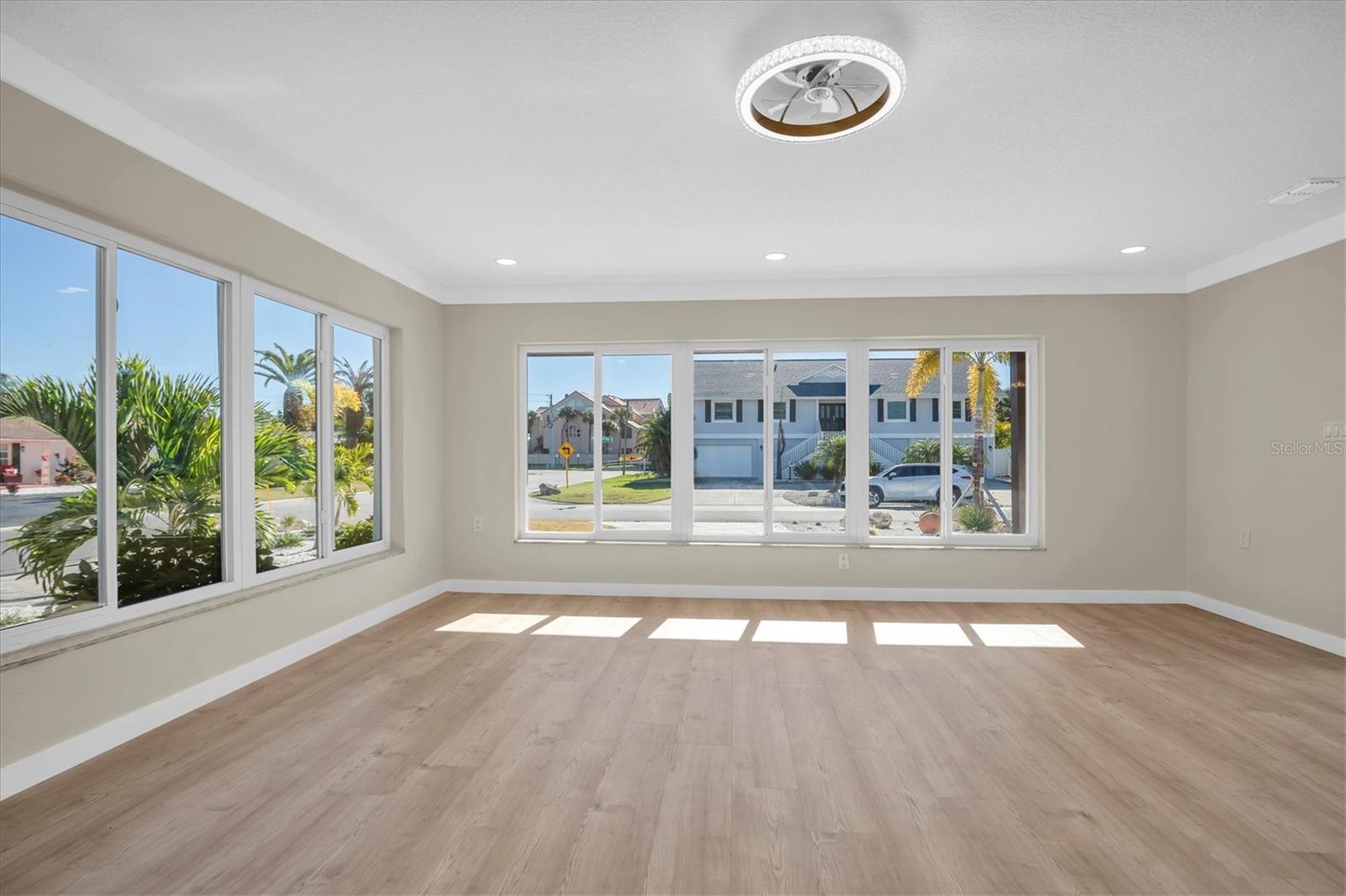 An expansive living room creates a sophisticated space for gatherings, framed by stunning windows.