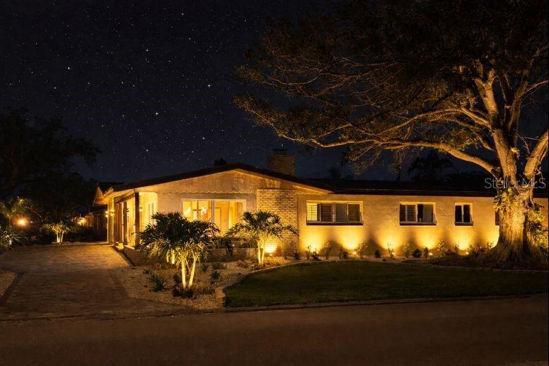 Enhanced by beautiful landscaping & elegant evening lighting, the side yard offers a refined outdoor ambiance that truly makes the home shine.