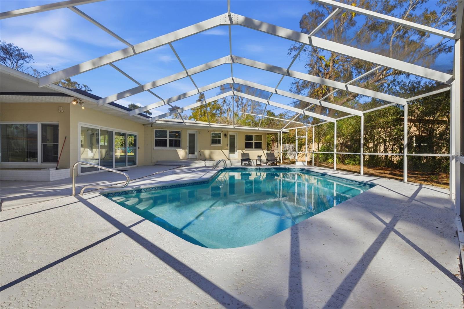 View of pool, family room sliding doors and two bedrooms