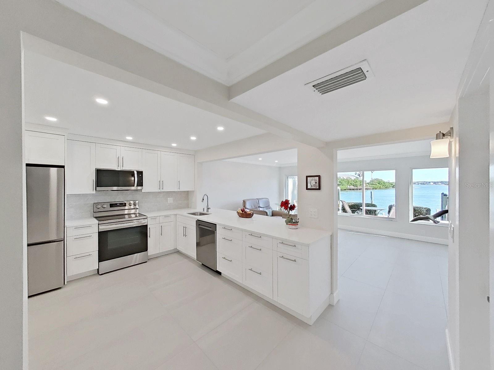 The kitchen features modern white cabinets