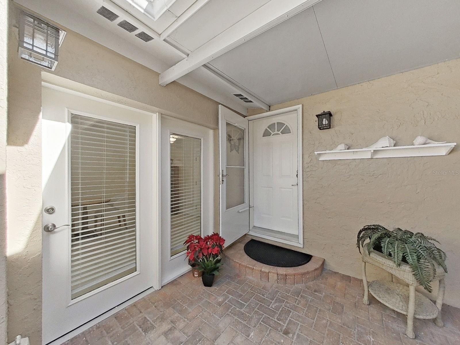 The entry door features a glass storm door. Separate double entry doors into the 1st floor en-suite.