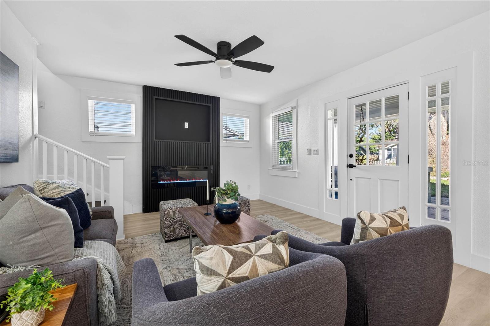 The living room is anchored by a modern electric fireplace, creating a warm, inviting focal point.