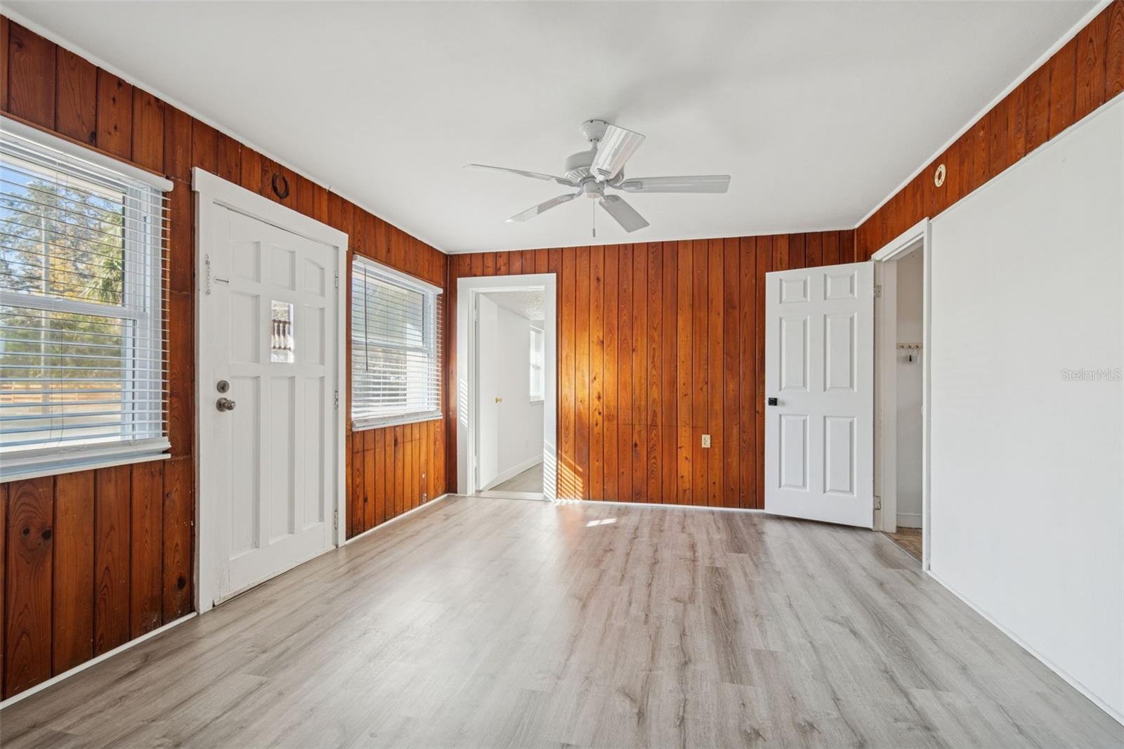 Bonus room with original knotty pine accent walls and side entrance to driveway