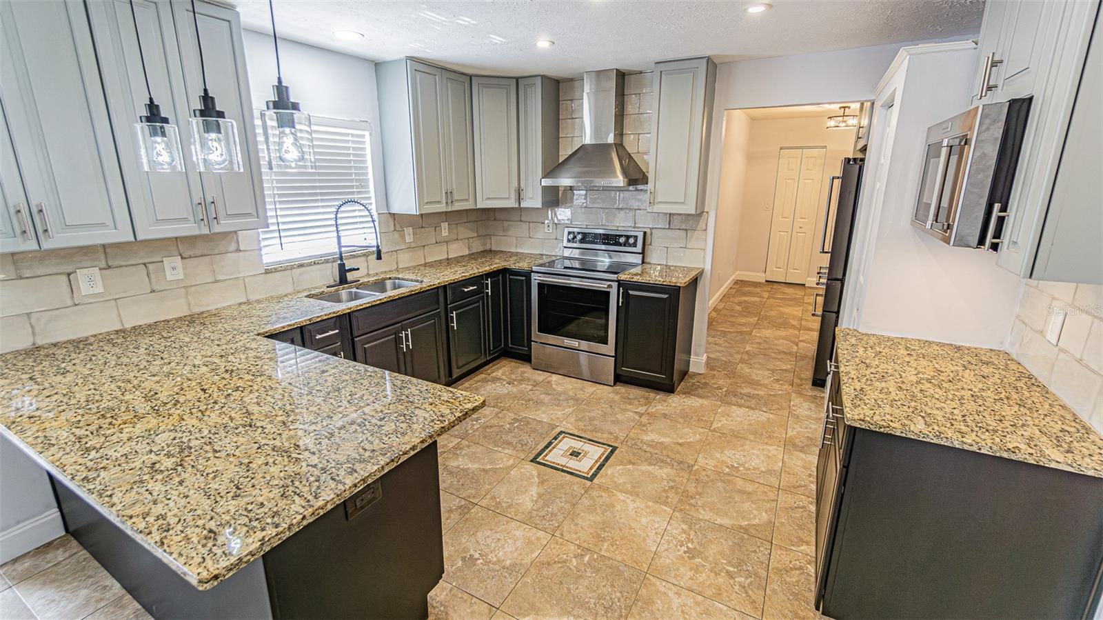 Updated kitchen with Espresso lower cabinets, Gray upper cabinets, Granite Tops, custom lighting and Stainless Steel Appliances-great for entertaining.