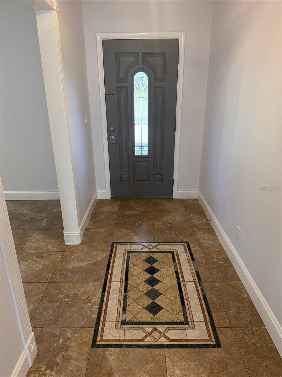 Foyer with custom inlaid tile,  House has 17" tile throughout