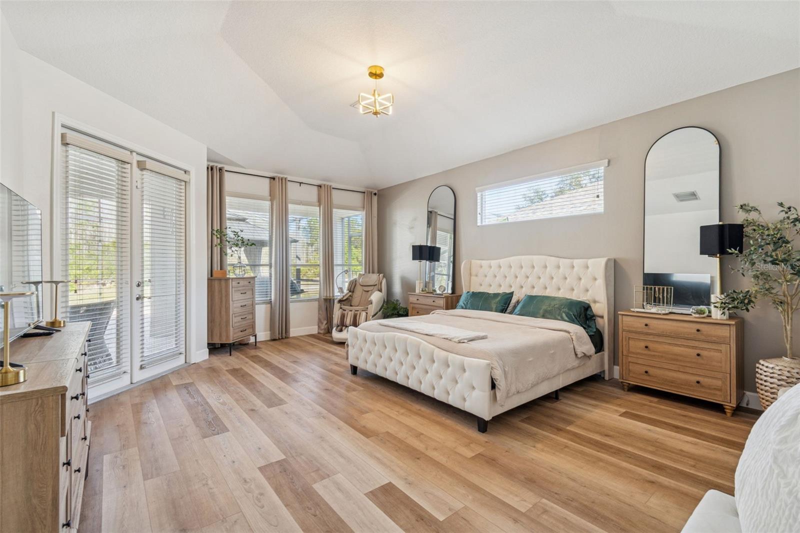 Primary suite boasts luxury vinyl plank flooring and new lighting.