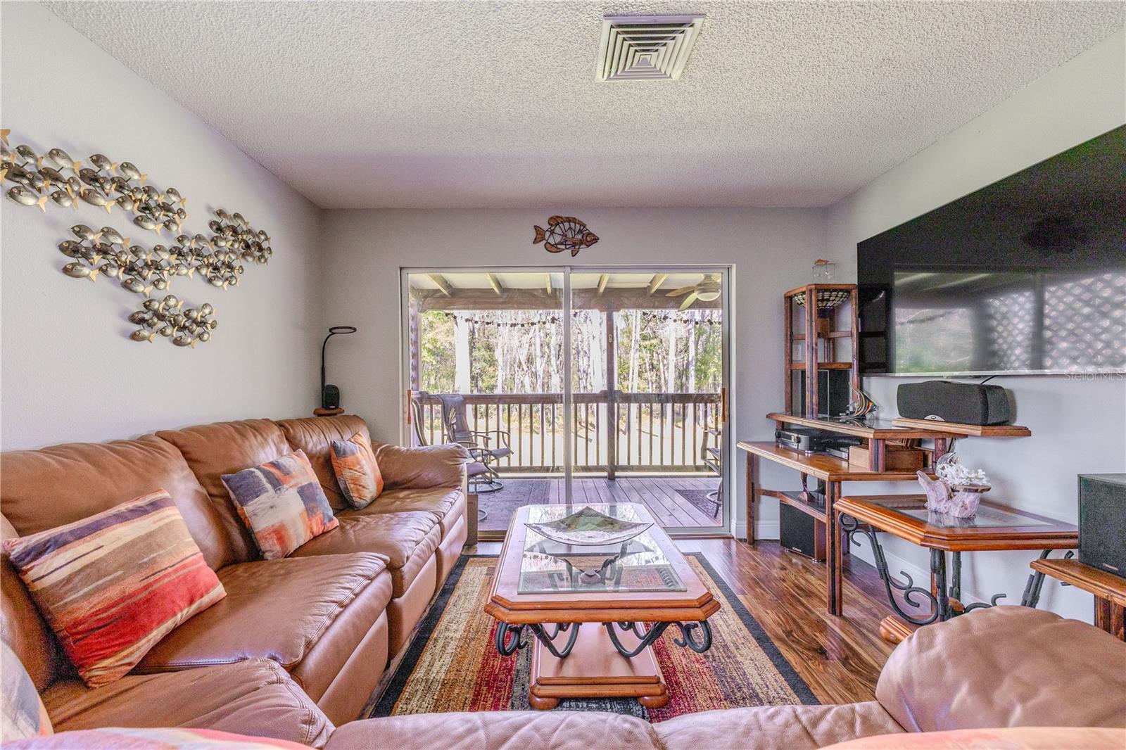 Well-proportioned family room designed for relaxed gatherings, with ample wall space for furniture placement. Sliding doors provide easy access to the deck, while neutral tones and wood-look flooring create a warm, cohesive backdrop.