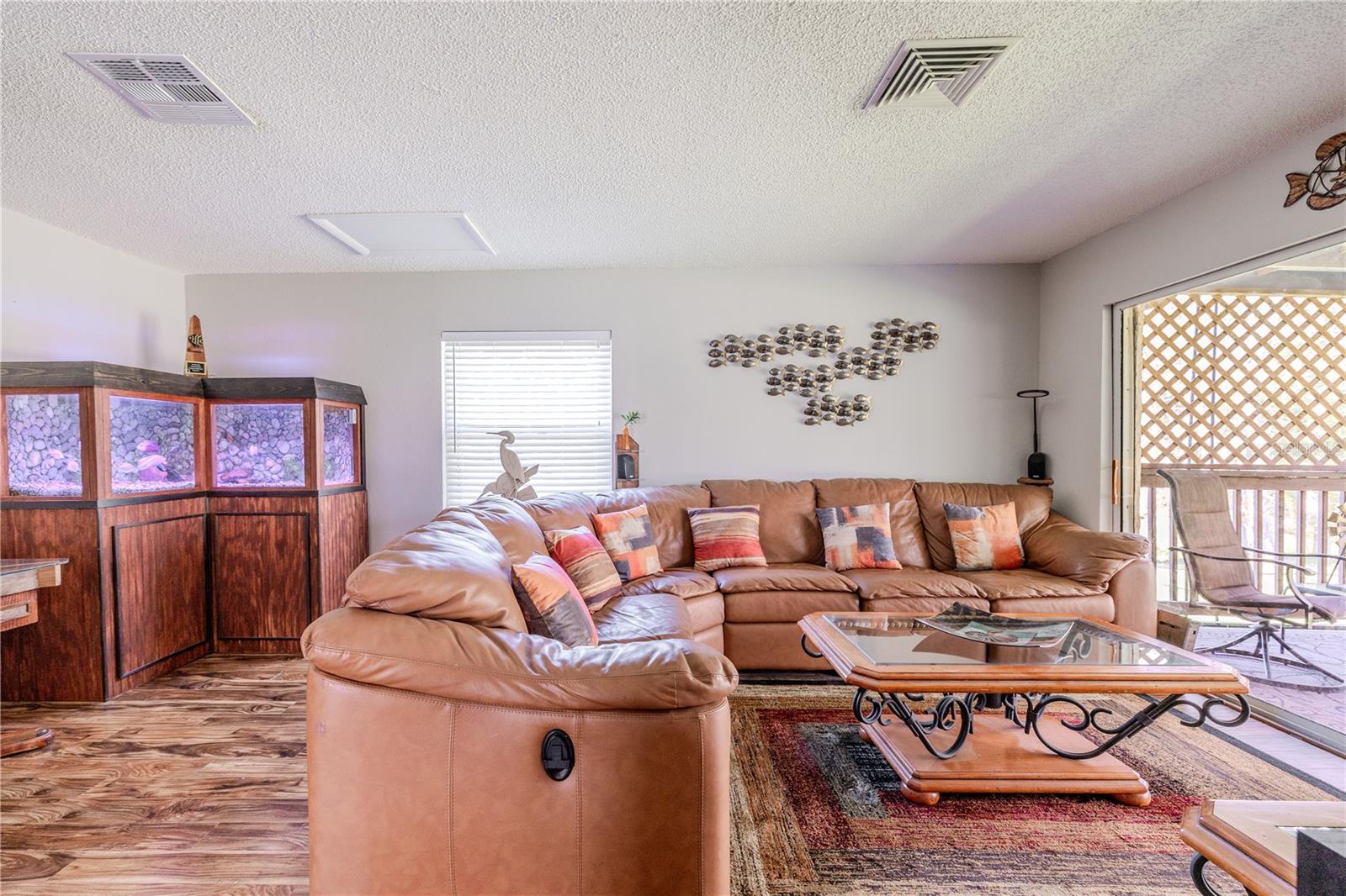 Expansive family room with ample room for sectional seating, highlighted by laminate flooring that adds warmth and continuity throughout the main living areas. Large sliding doors allow natural light to fill the space, while the open layout keeps the room connected to the rest of the home.