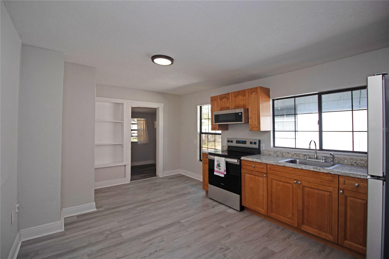 Open kitchen with newer cabinets and appliances.