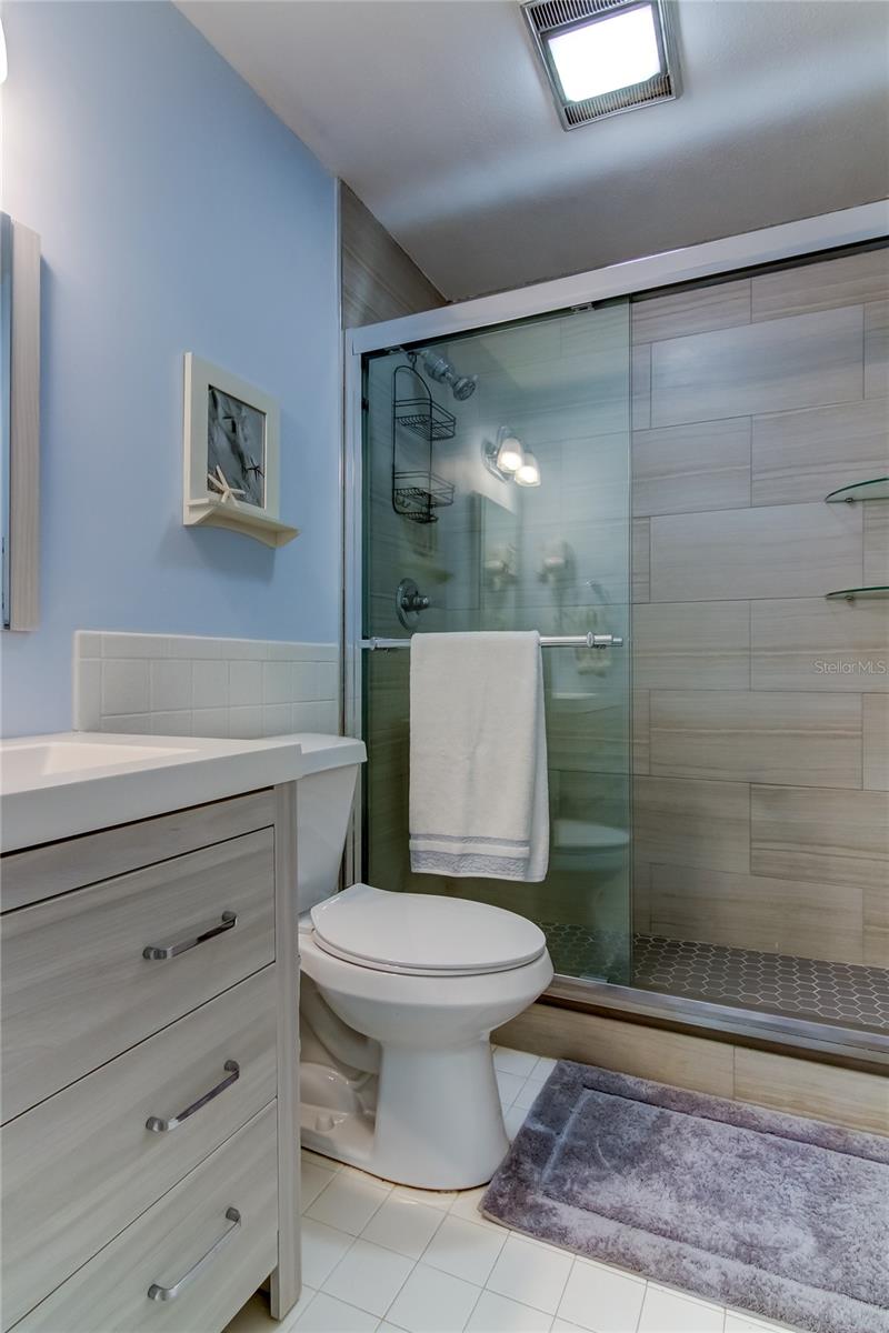 45. FULLY Updated Hall Bath.. Tastefully Chosen Hexagon Tiles, Built In Glass Shelves + Glass Doors Are Sure to Impress!