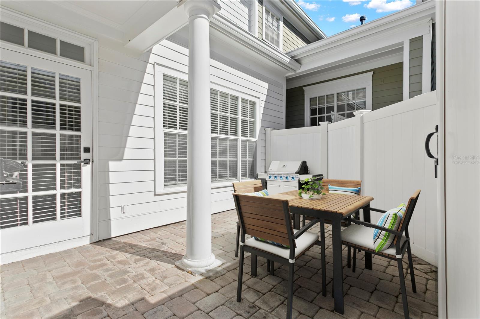 Virtually staged image, Just off the living room, the back porch offers the perfect space for grilling and outdoor seating.