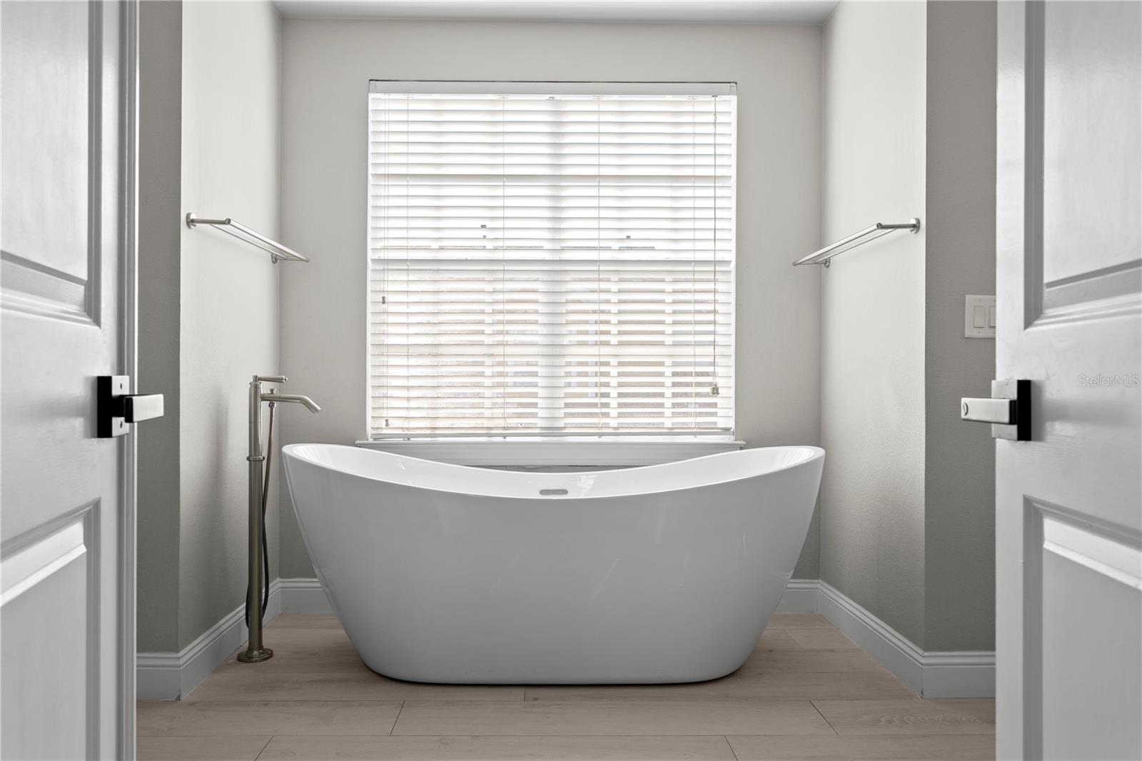 The primary en suite bath is a true retreat, featuring a large soaking tub, walk-in shower, dual vanities, and a separate water closet.