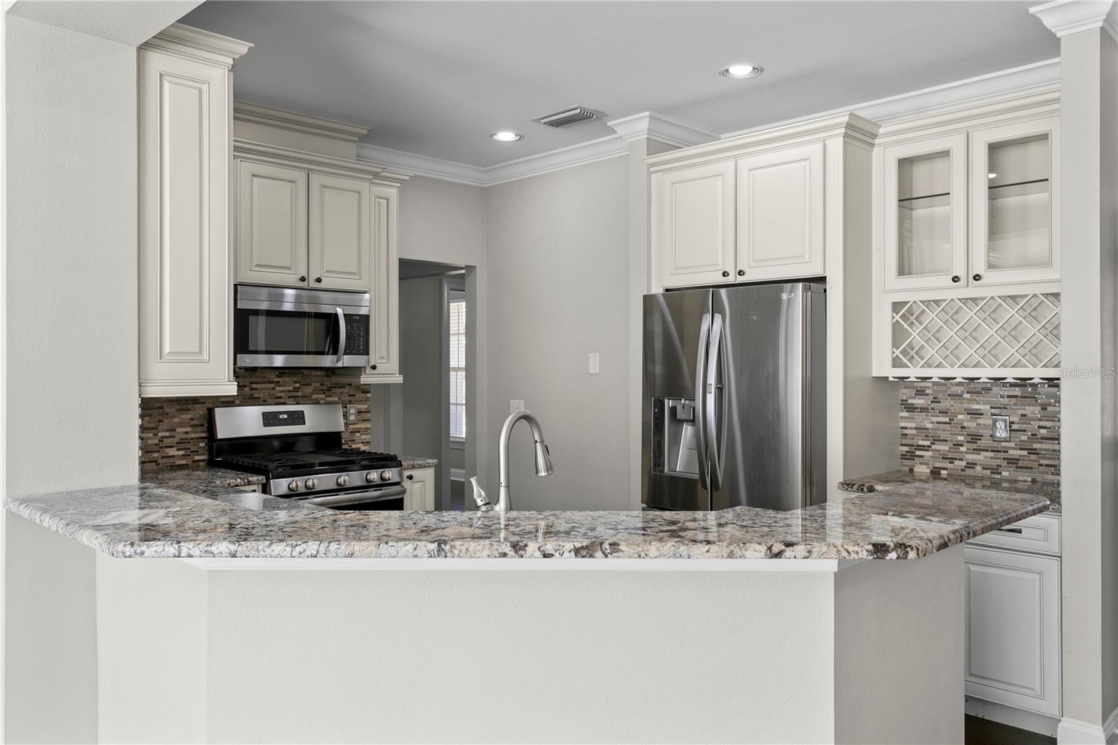 Updated kitchen with stainless steel appliances, dedicated wine storage, and ample countertop space for easy prep and entertaining.