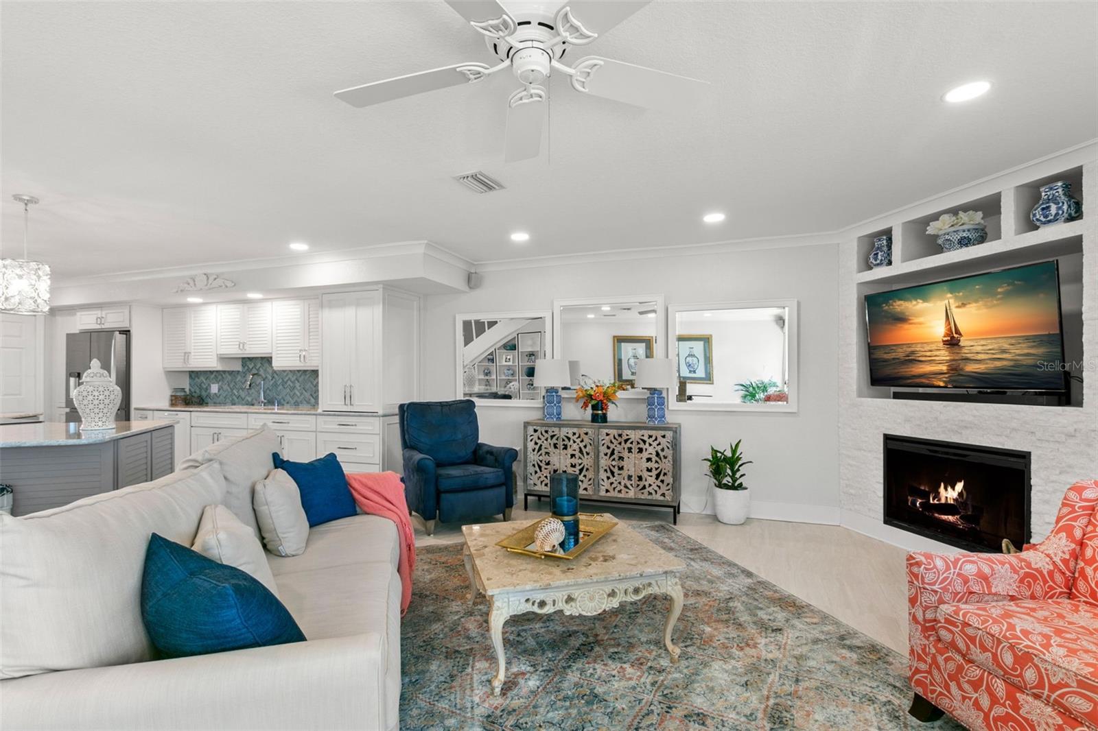 Inviting living space centered around a custom fireplace and built-in display niches, featuring comfortable seating areas and an open flow back to the kitchen.
