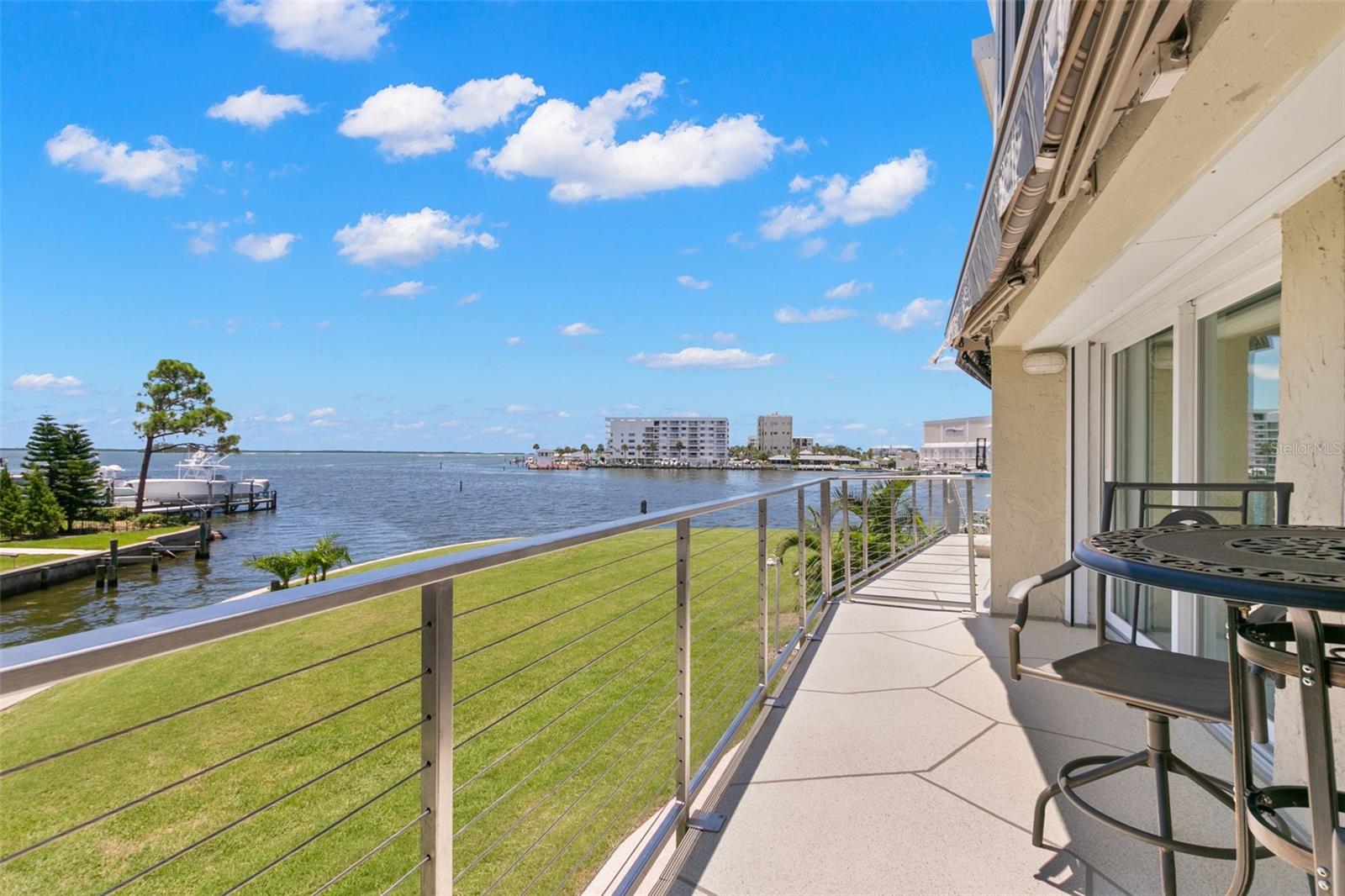 Private deck overlooking the Intracoastal, featuring open water views, manicured green space below, and expansive sightlines across the surrounding waterfront communities.