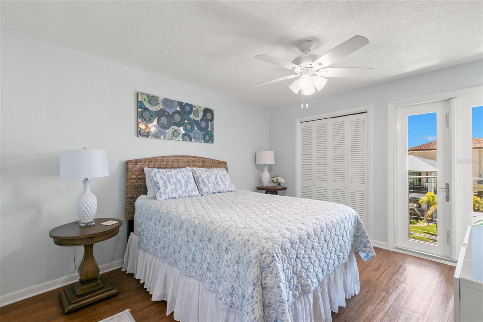 Bright and well-proportioned bedroom with soft neutral walls, luxury vinyl flooring, and a ceiling fan for year-round comfort.