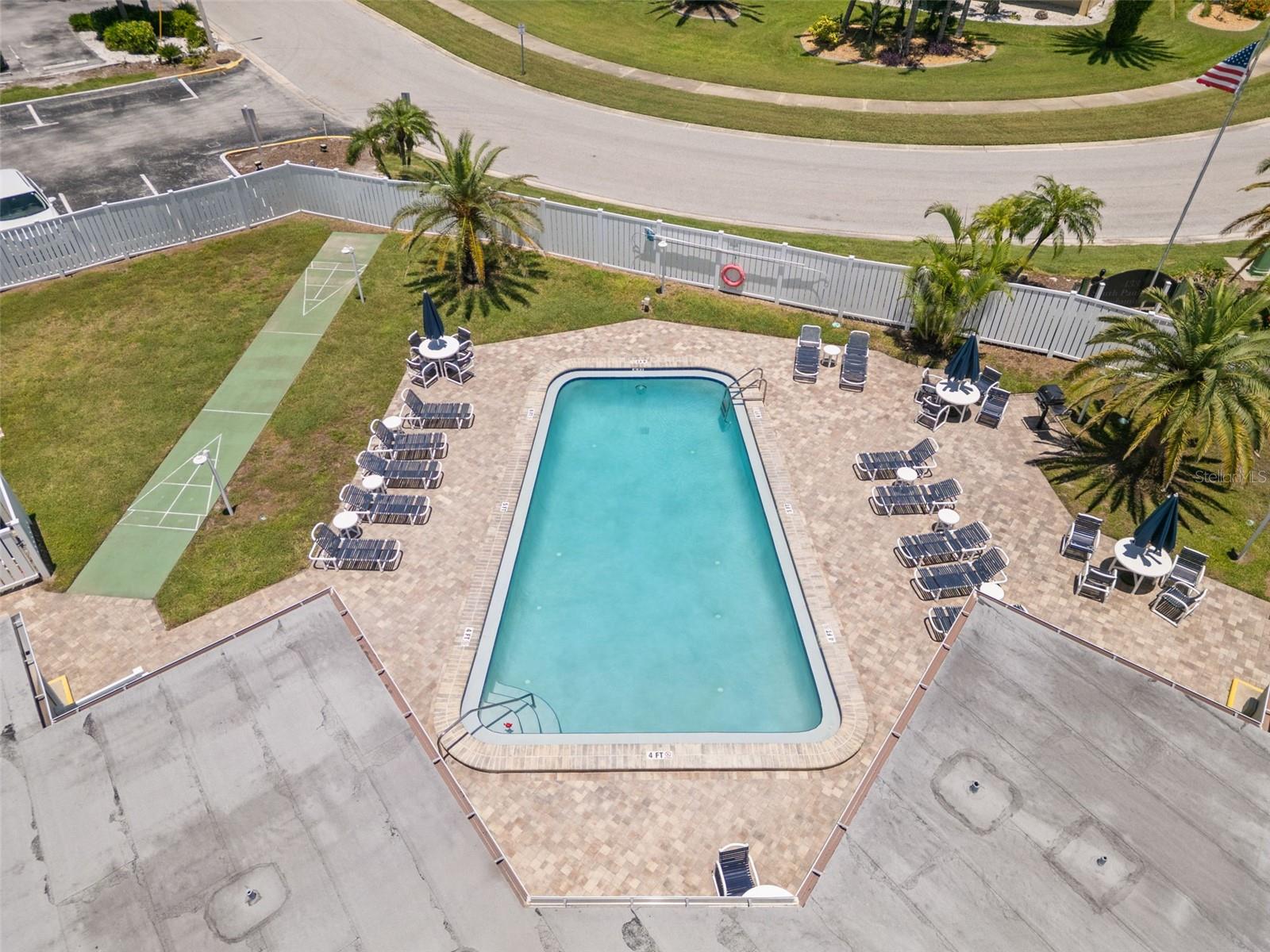 Aerial view of the community heated pool and shuffle board area.