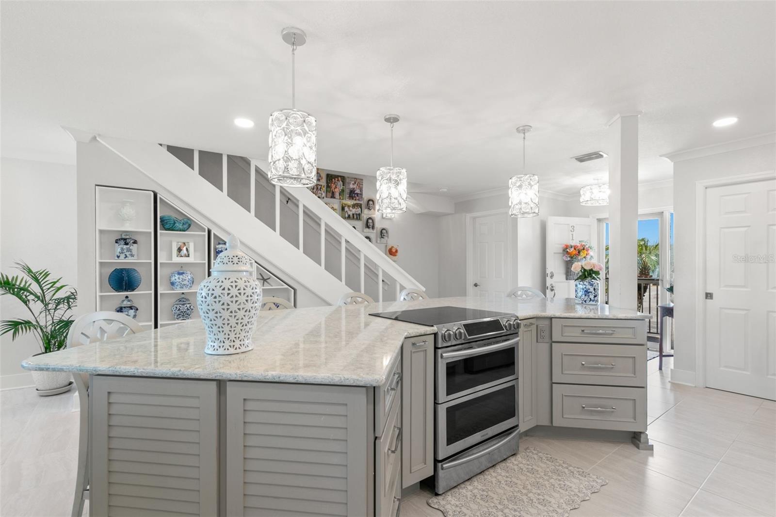 Kitchen island with built-in storage set alongside an open staircase and custom shelving, blending function with architectural interest.