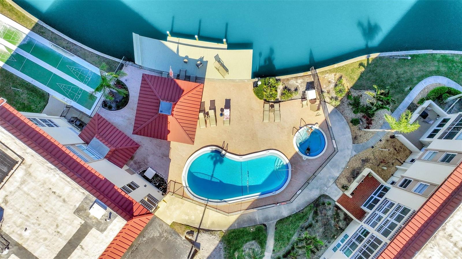 Aerial showing the pool and hot tub area facing the water