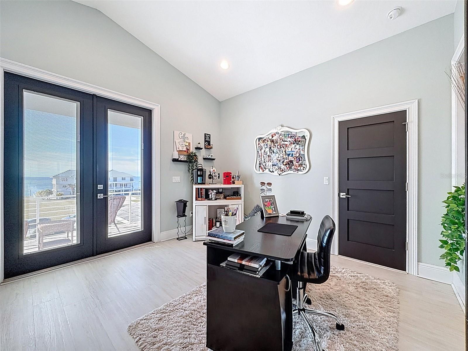 An additional sitting room or bonus space opens to a front balcony showcasing sunset views over the Gulf.