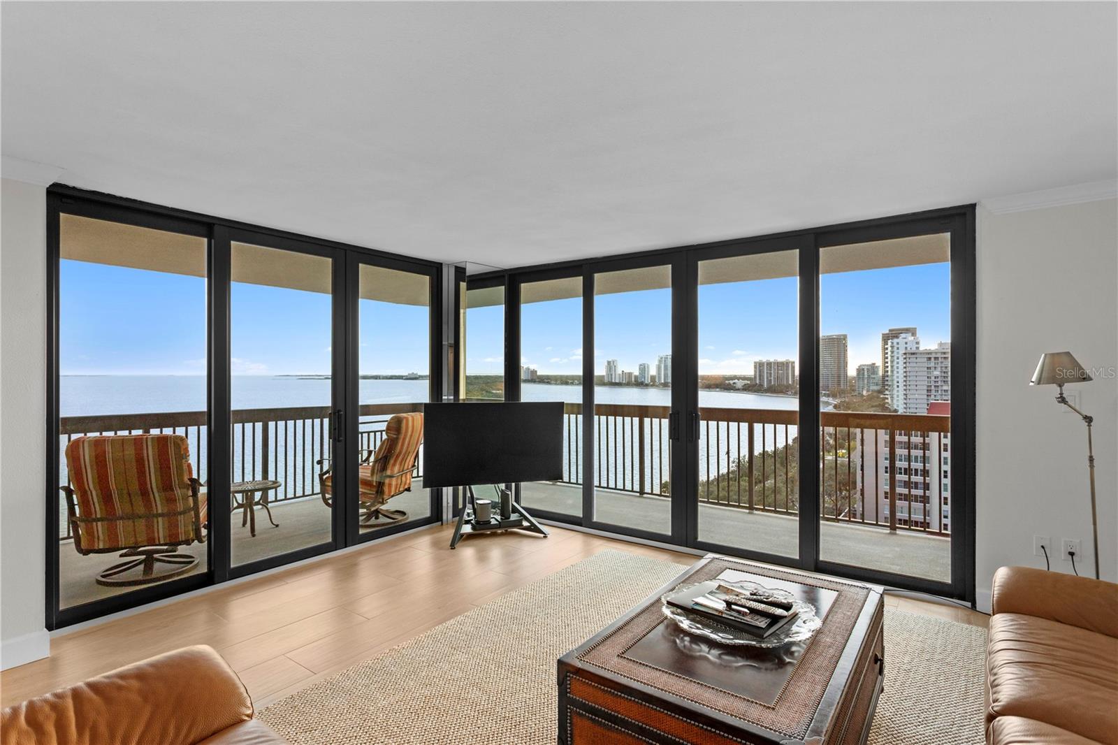 The living room provides access to the well-appointed balcony offering seating and sweeping city skyline and sky views.