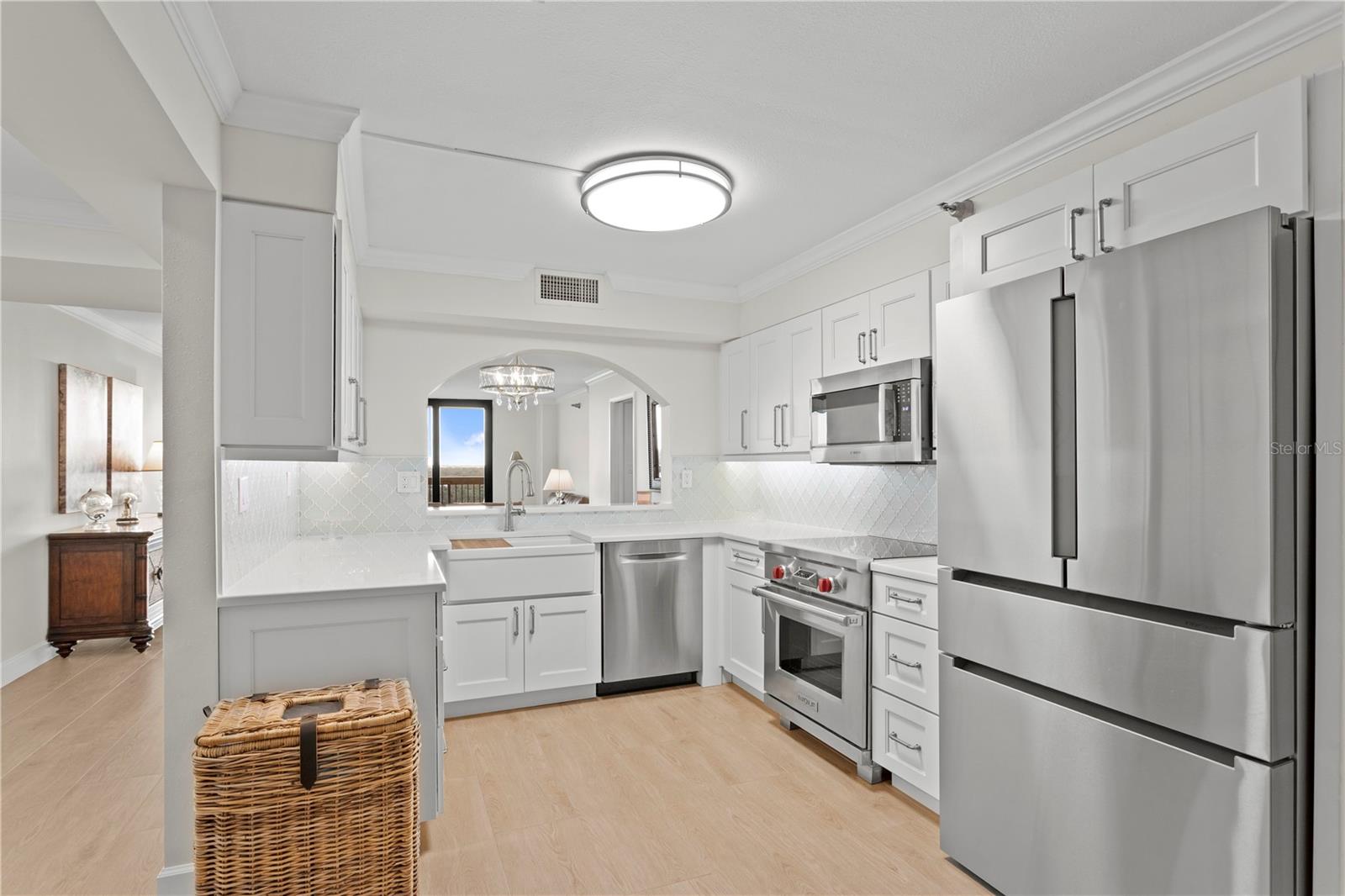 The chef’s kitchen is a showpiece, offering abundant custom cabinetry topped with quartz countertops, a Wolfrange and oven with overhead microwave, an oversized stainless-steel refrigerator, an ultra-quiet dishwasher, and a charming farmhouse sink.