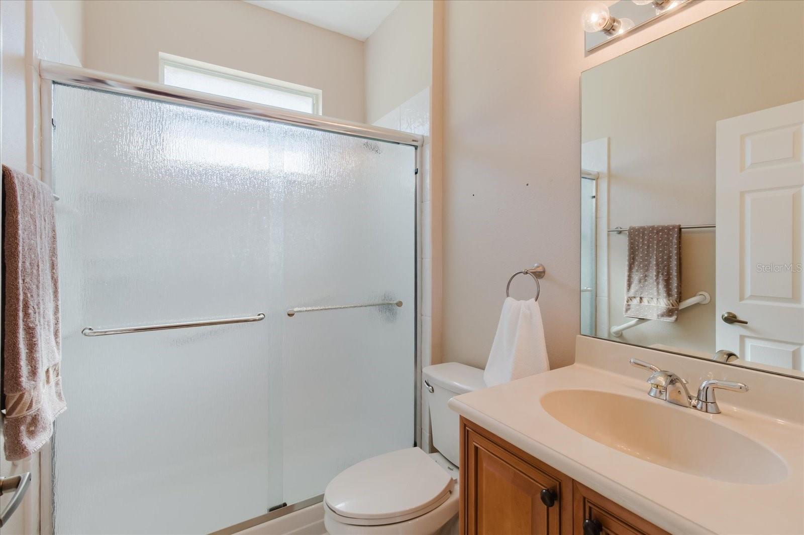 Second bathroom with rain glass tub doors