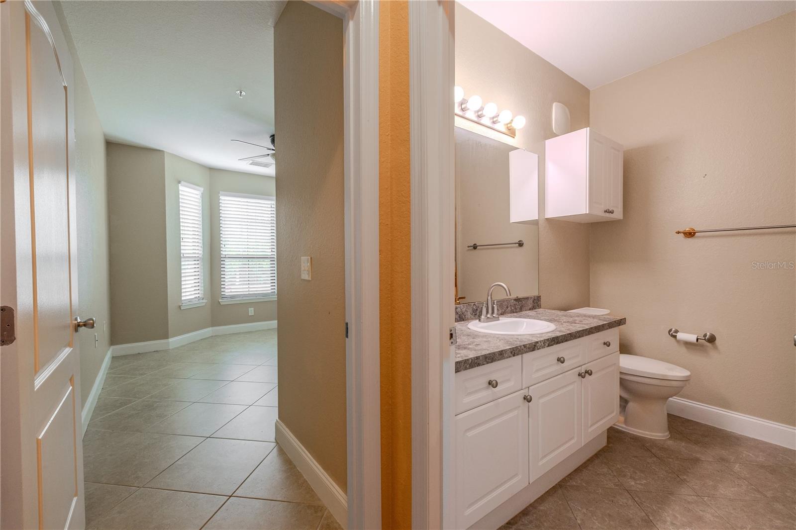 Bedroom 2 is conveniently located near the hall bath and features tile flooring, neutral walls, and an easy layout that works well for guests or everyday living.