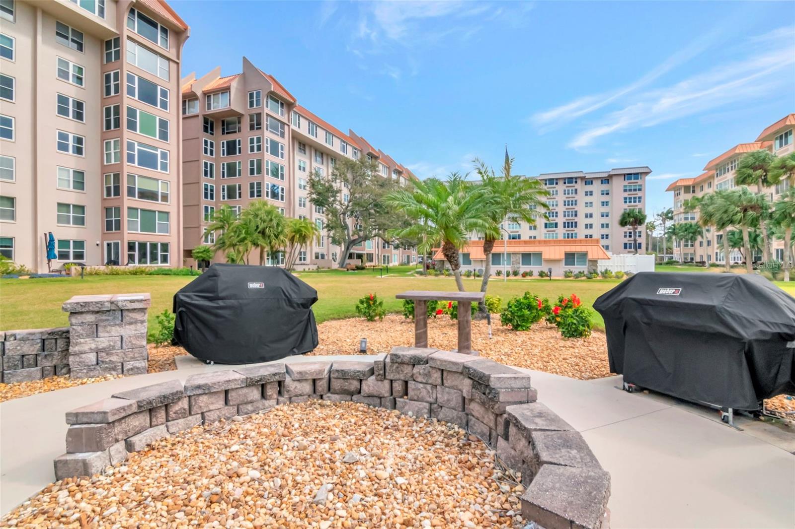 Gas grill cook out area with heated pool and managers office in the background.
