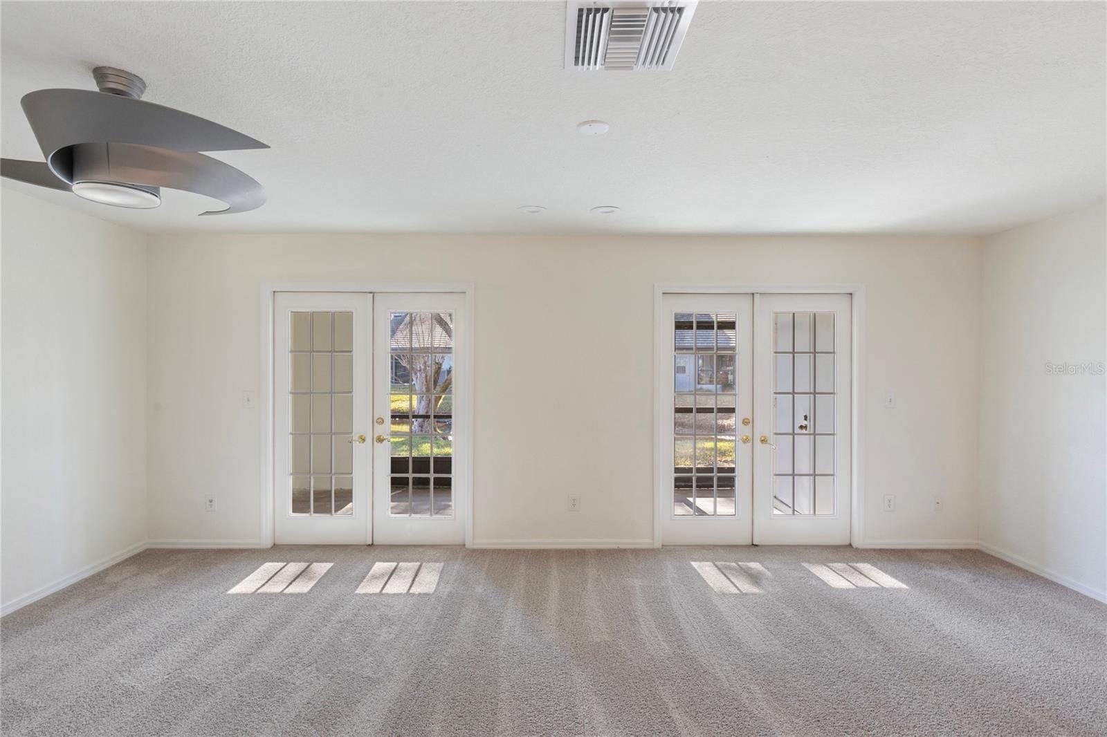 Living area with dual doors out ot the lanai adds lots of pleasant afternoon light into the space.