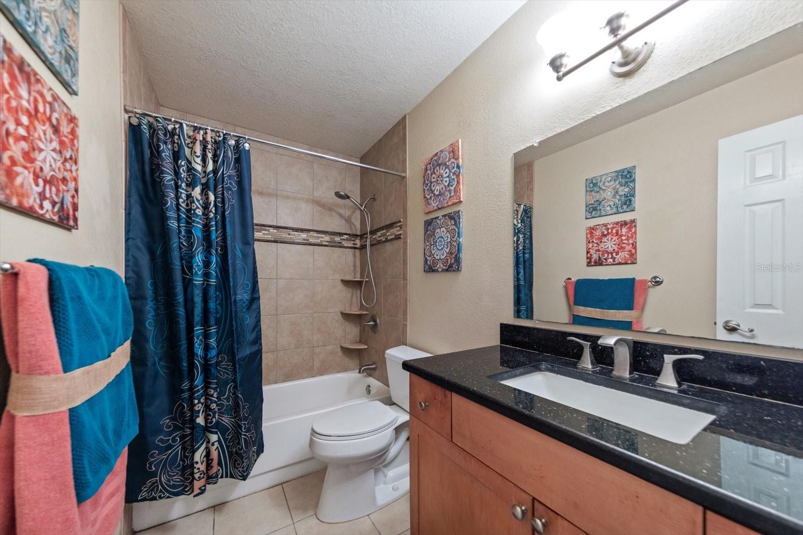 Upgraded bath with granite countertop, updated bath tile w/built ins and tub freshly reglazed (2026)