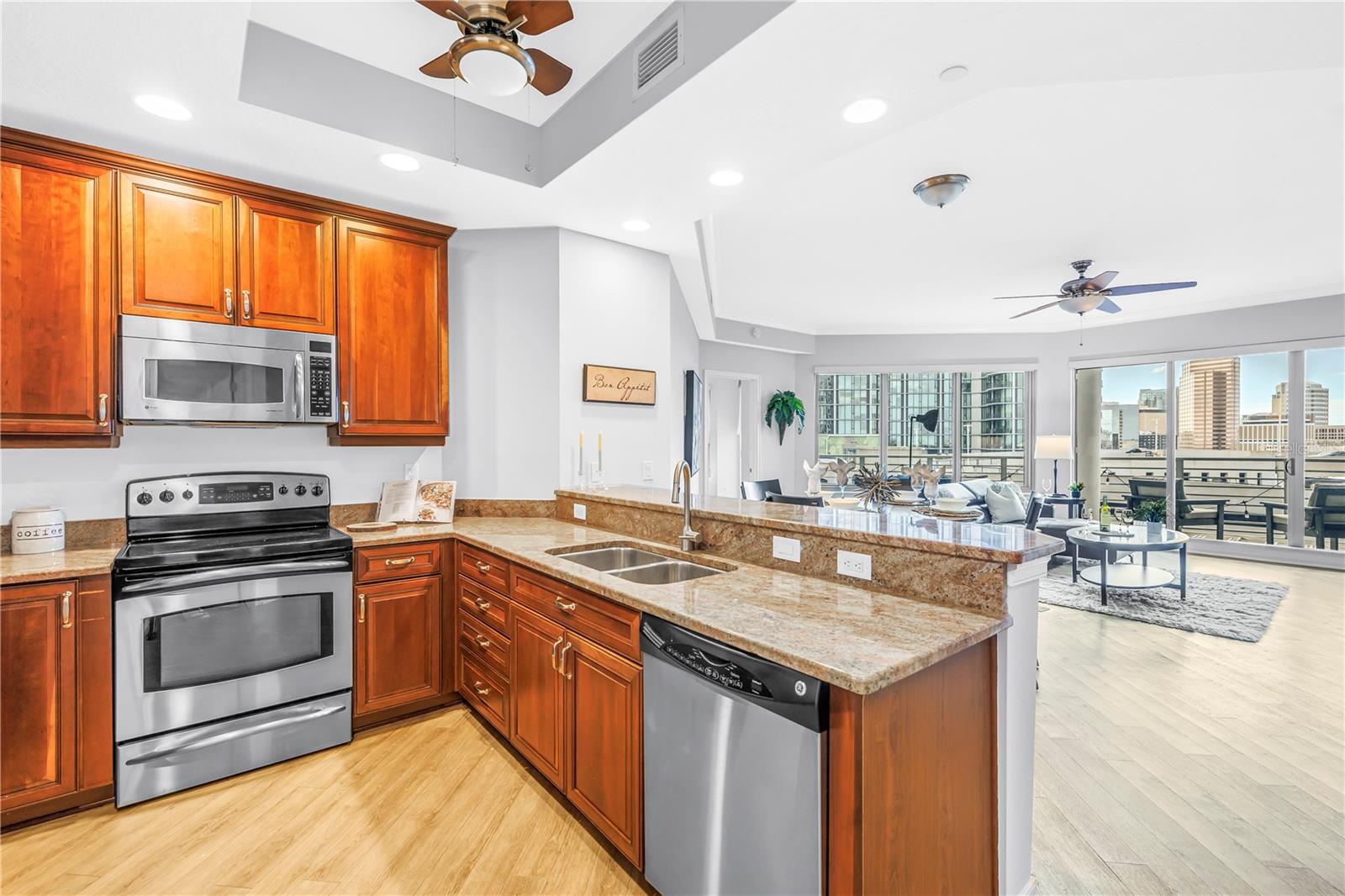 Open Kitchen with Granite High Top Seating and Easy Conversation to the Living, Dining, and Outdoor Space.