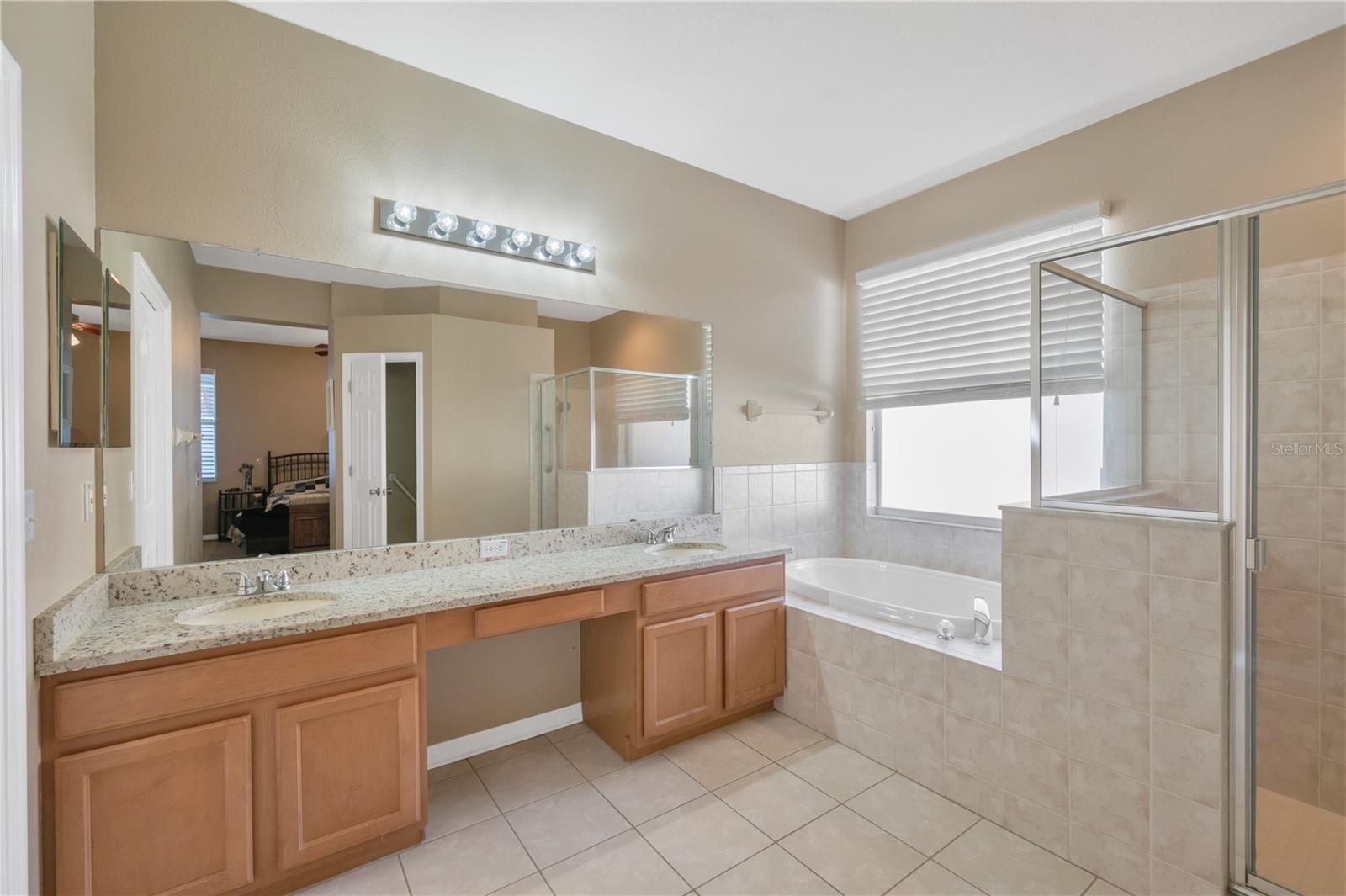 The primary suite has a spa-inspired en-suite bath with dual sinks on a large vanity, a separate soaking tub and shower.