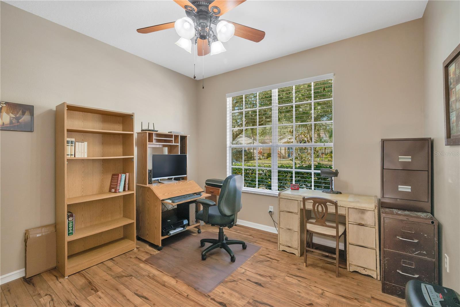 Bedroom/Den/Office just inside the front door with laminate flooring, a ceiling fan and a double door entry. (No Closet)