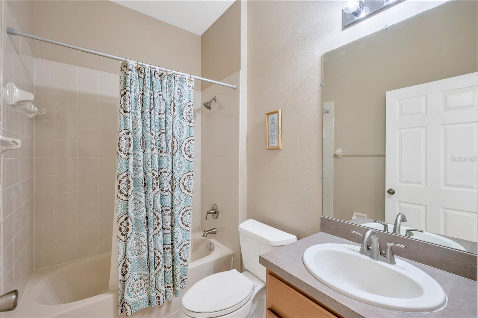 This guest bathroom has an updated sink, faucets and shower fixture.