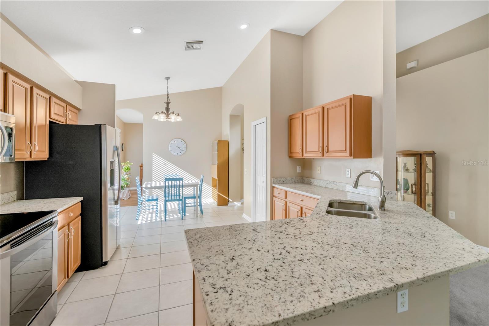 The kitchen features granite countertops and an expansive breakfast bar, ideal for both everyday cooking and entertaining.