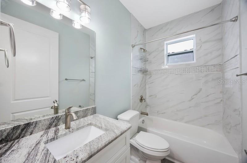 Secondary bathroom: Tub-shower combo and granite countertops