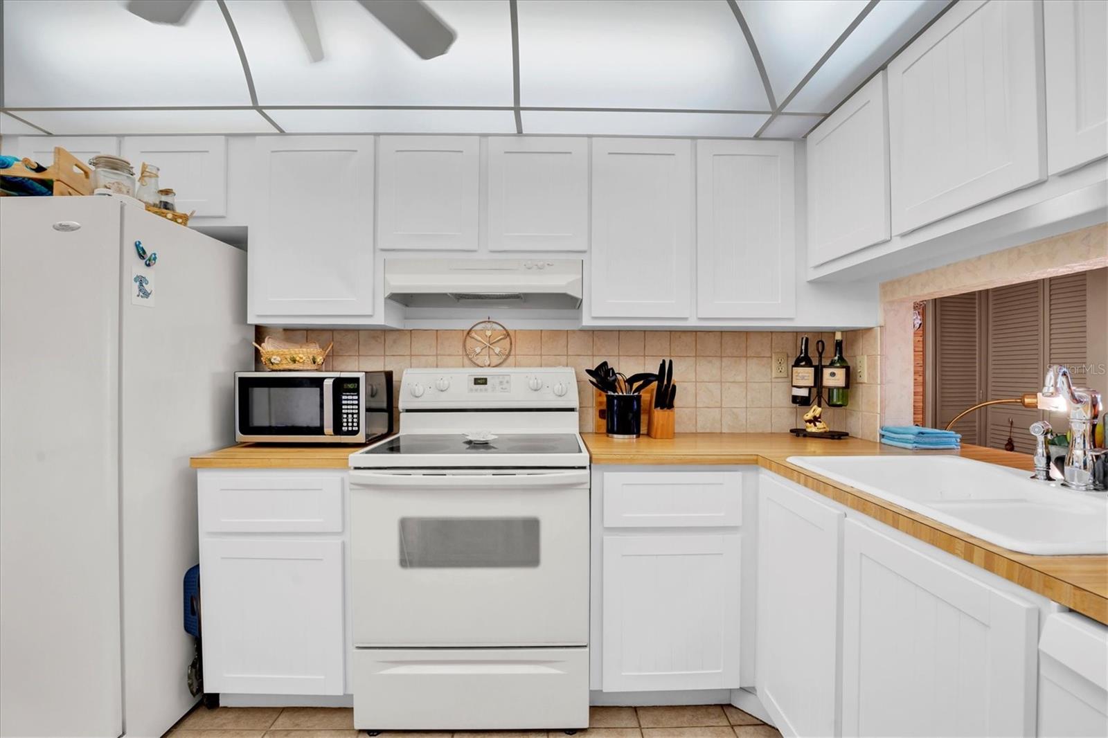 Kitchen has pretty white cabinetry
