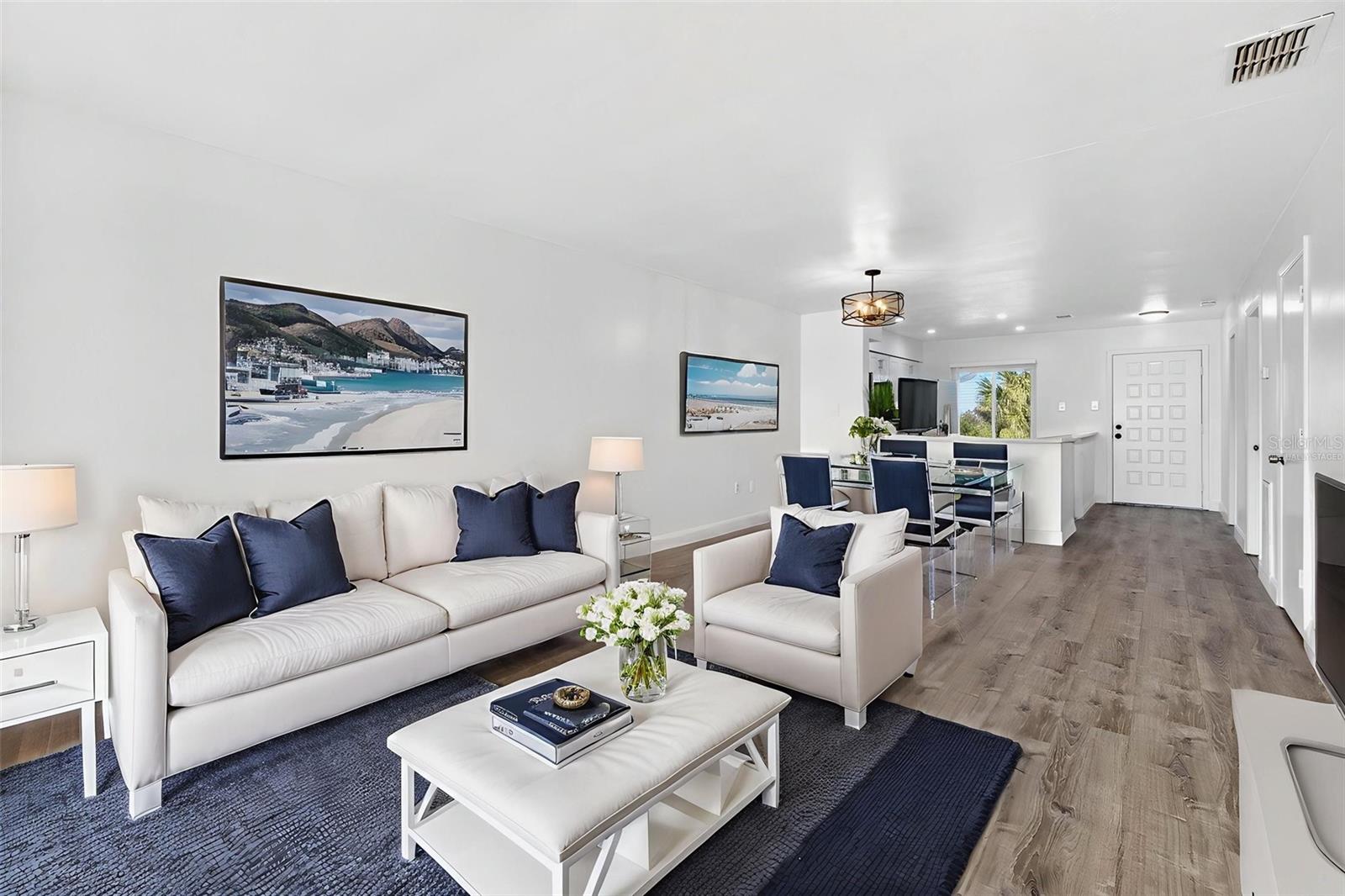 Virtually Staged. Lightly-filled, open-concept living with luxury vinyl flooring and Gulf views through impact windows. Sophisticated and supremely livable.