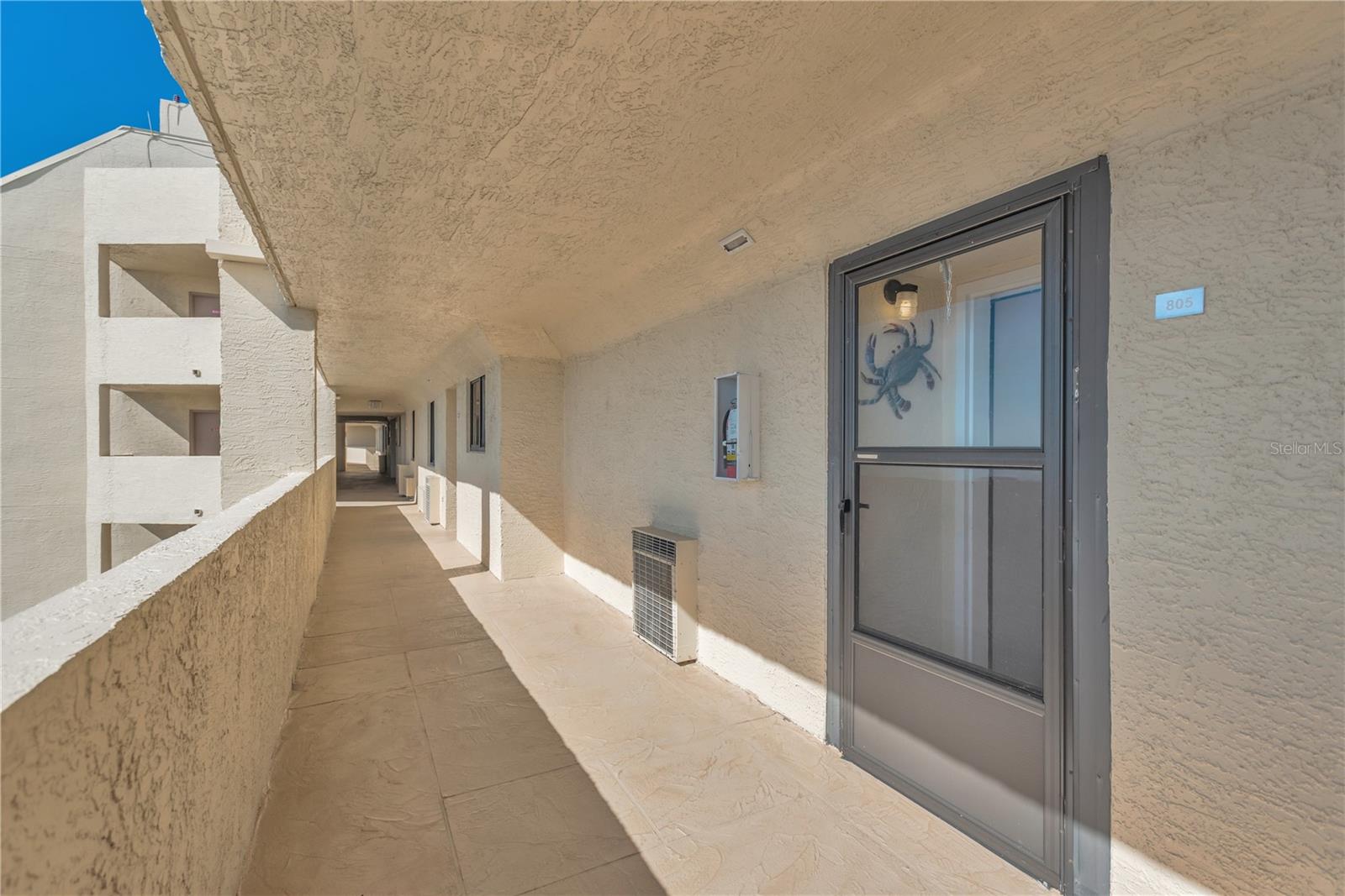 Walkway to front entrance to unit 805.  Storm door protects inside entry.