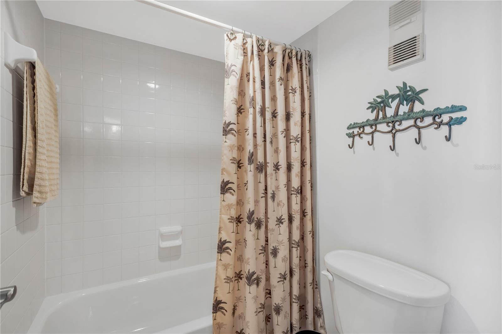 Master Bath with tub/shower combination and commode.