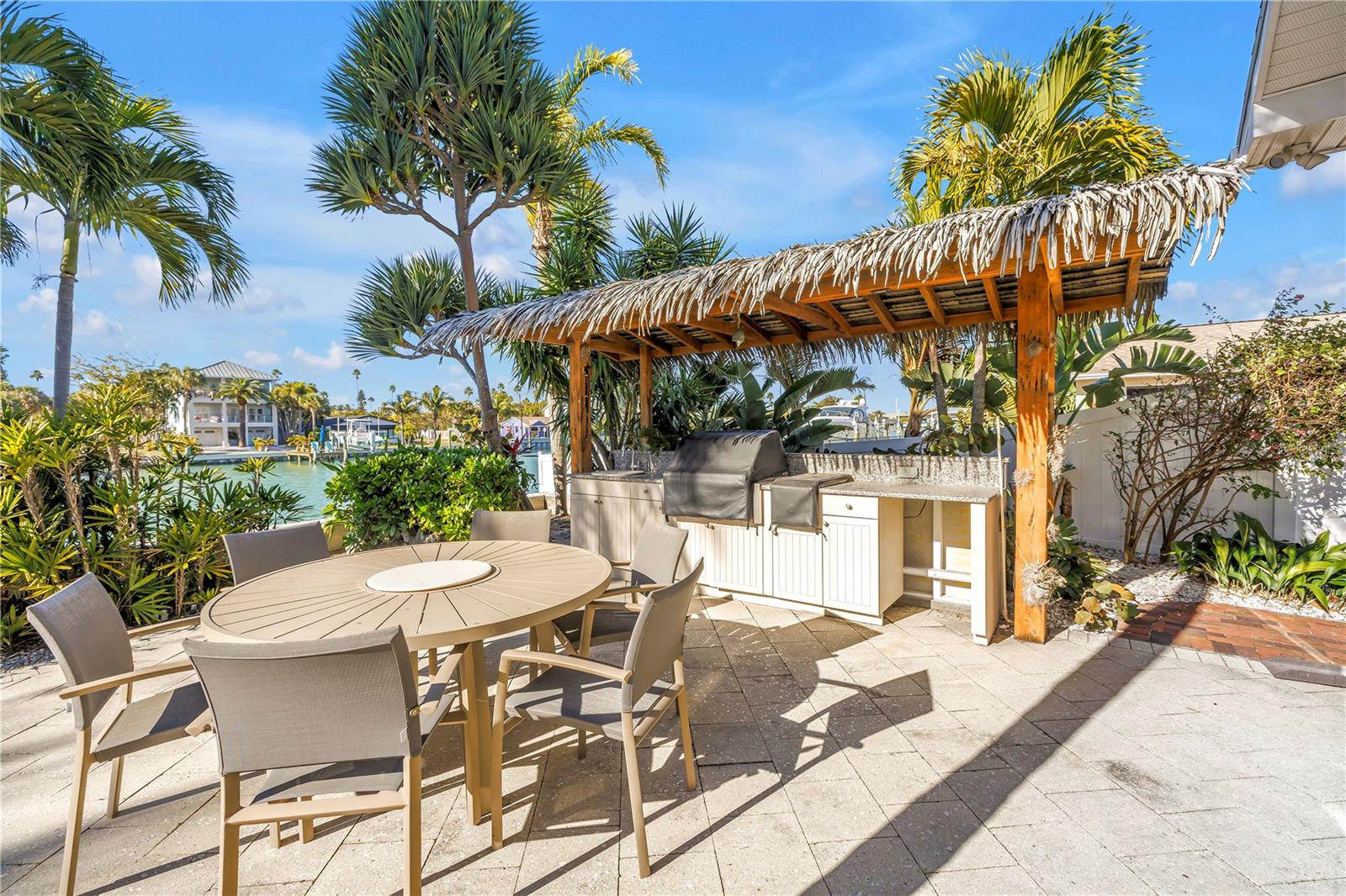 Outdoor Tiki hut style BBQ, sink with waterfront dining