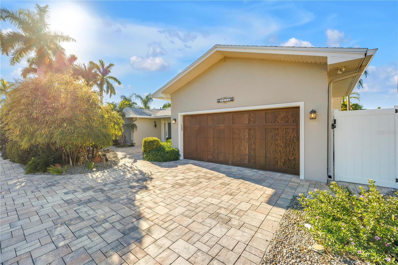 Front yard pavers and lush landscaping, garage entrance