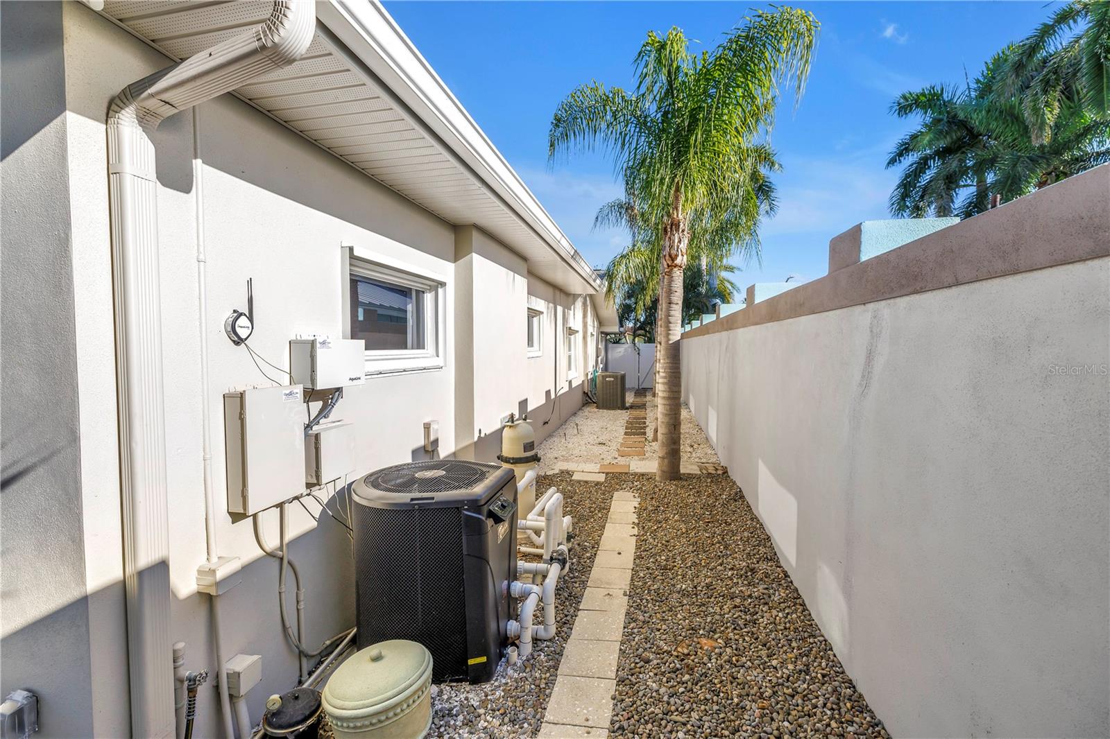 Wider gated entry on right had side of house leading with side-door entrance to the house leading to backyard