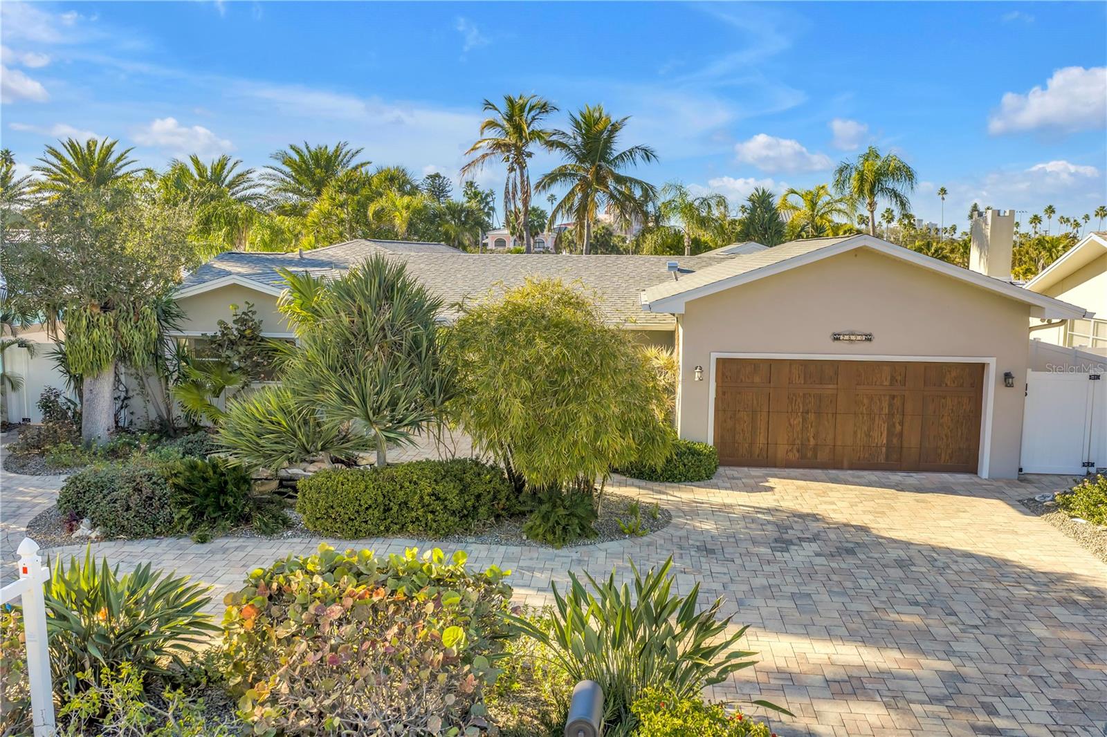 Front yard pavers and lush landscaping with water feature, garage entrance