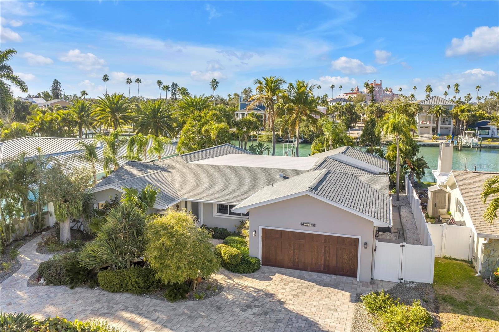 Front yard pavers and lush landscaping with water feature, garage entrance